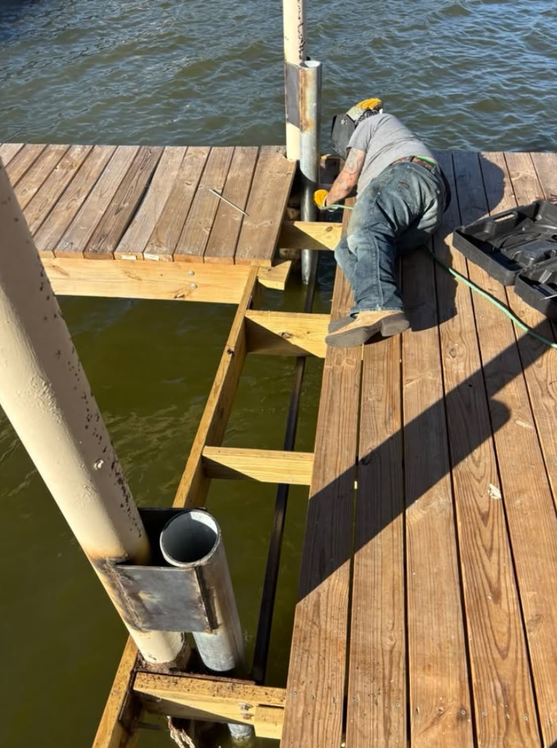 Replacing dock framing over the water, new timber bracing bolted to the pipe piling